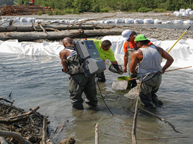 Photo of people working in a river.